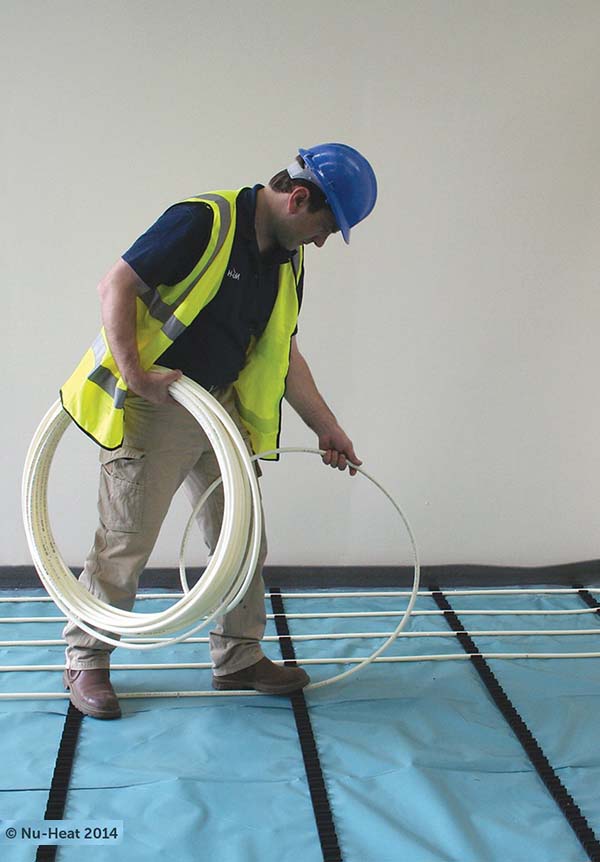 Man installing Nuheat underfloor heating system